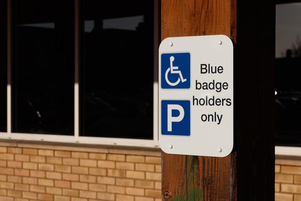 A blue sign for disabled badge holders parking