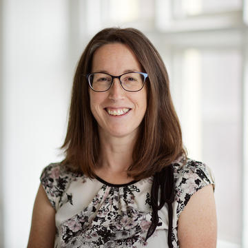 An image of Laura Epton wearing a floral top and smiling against a white background.
